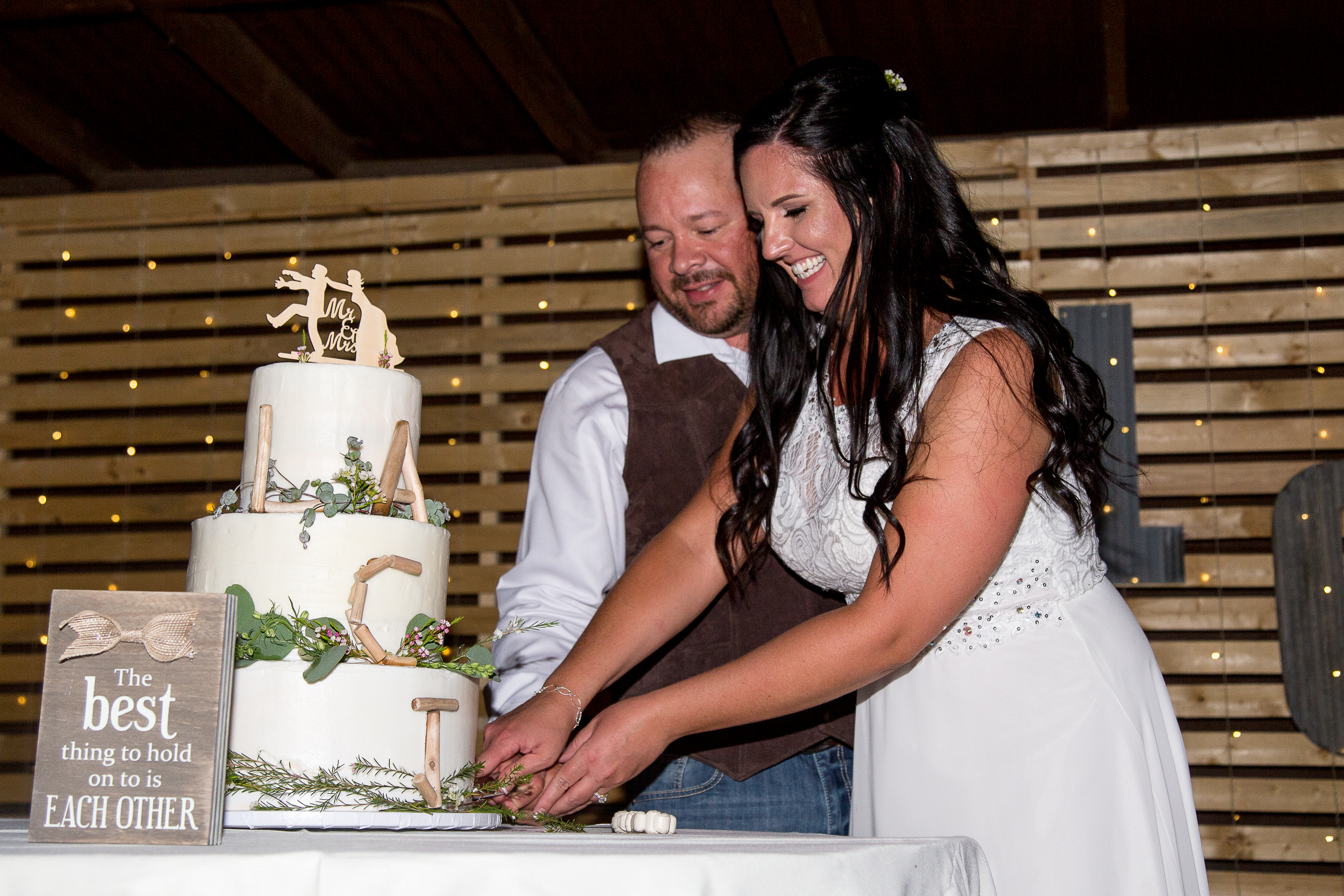 Three tier wedding cake with couple cutting the cake.